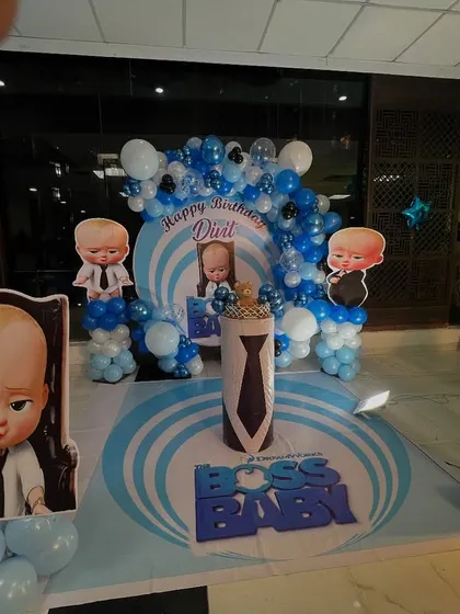 I create custom-themed birthday parties for kids. This entire setup was designed for a "Boss Baby" theme, including the printed backdrop, character cutouts, a themed cake stand, and a large marquee number '1'.
