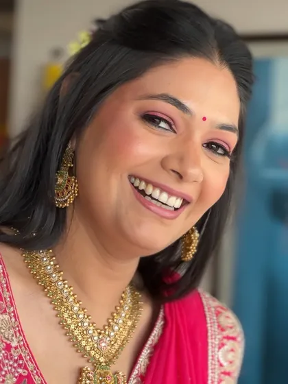 A bright, happy smile from a bride who looks as fresh as a flower. The pink liner adds a playful touch to the makeup, perfect for a daytime wedding event.