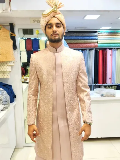 This heavy embroidery open-sherwani in a soft peach color is a popular choice for modern grooms. It’s a versatile piece that pairs beautifully with a bride's red or maroon lehenga.