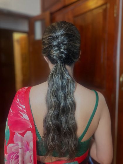 A modern ponytail with a braided detail at the top. This adds a touch of intricacy to a classic style.