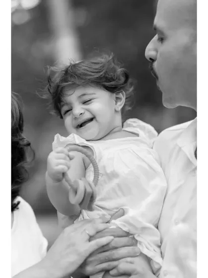 Another perspective of the joyful family moment, presented in classic black and white. This version highlights the textures and the genuine smiles shared between parent and child.