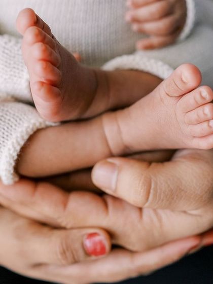 Another beautiful shot of parents' hands holding their baby's tiny feet. A simple way to show just how small they are.
