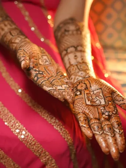 A close-up of a detailed bridal design, showcasing the fine lines and shading. The central panels feature a Ganesh figure and a doli, classic elements for any bride.