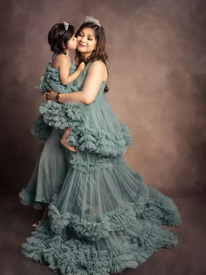 A sweet kiss between a mother and her little princess. I offer a selection of beautiful gowns for both moms and daughters, like these matching ruffled dresses, to add a touch of fairytale magic to your session.