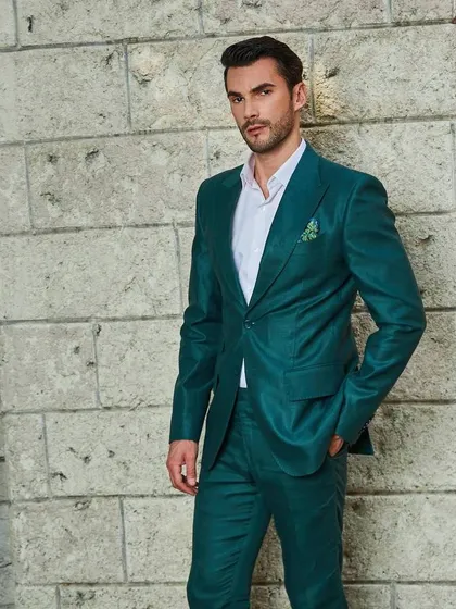 Another look at the green linen suit, highlighting its rich color and the way it complements a simple white shirt. The pocket square adds a final touch of polish.