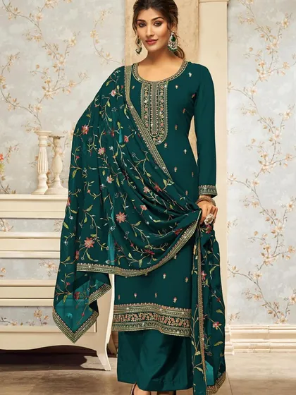 A beautiful teal salwar kameez with a heavily embroidered dupatta. The rich color and detailed thread work make it a sophisticated choice for any occasion.