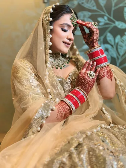 A lovely candid moment, showing the bride adjusting her maang tikka.