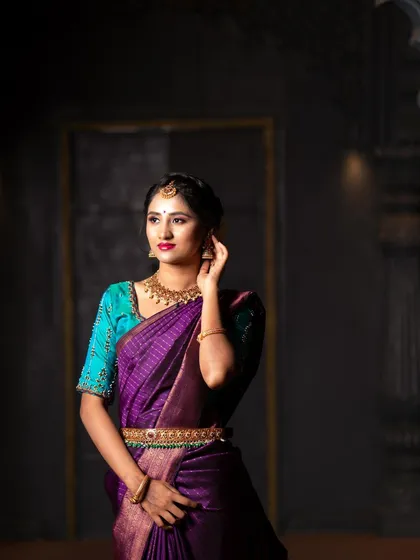 This is a glamour saree photoshoot where we played with shadows and light to create a dramatic, almost painterly effect. The goal was to make the rich purple of the silk saree pop while giving the portrait a timeless, regal feel.