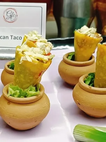 A taco with a twist! We serve our zesty Mexican taco filling in a crispy cone, presented in charming terracotta pots for a rustic yet playful touch.