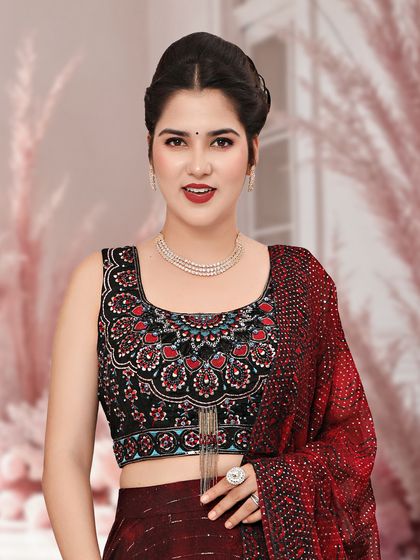 A close-up of a maroon lehenga with a heavily embroidered, sleeveless black blouse, a chic and modern combination.