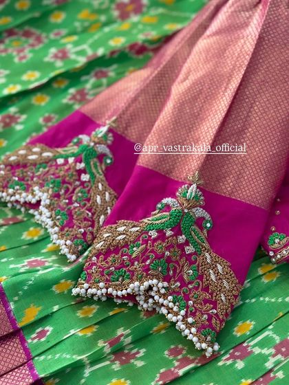 Pink sleeves with embroidered peacock feathers in green and gold.