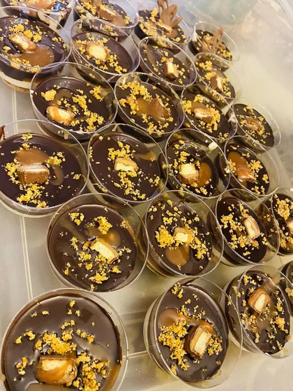 An order of my most popular dessert, the Twixter, ready to go in convenient individual cups. Each cup has layers of chocolate, caramel, and biscuit, topped with a piece of Twix for that extra crunch.