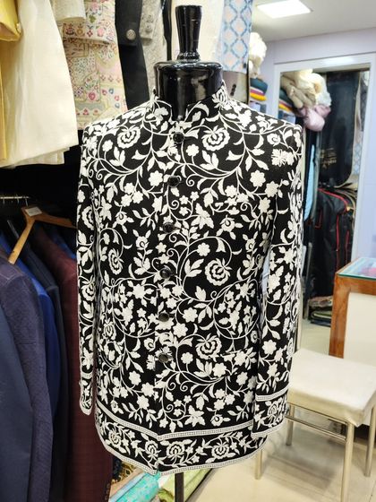 Inspired by celebrity style, this black Jodhpuri jacket features a bold white floral print. It's a modern, high-fashion piece for any wedding event.