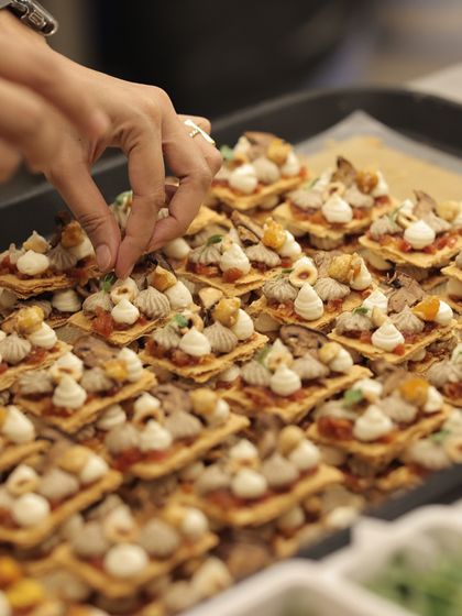 A tray of intricate canapés being prepared for an event, each one a small work of art.