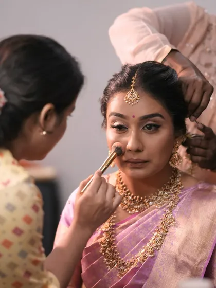 A behind-the-scenes moment during a South Indian bridal session. This is me, ensuring every detail is perfect, from the base application to the final touches.