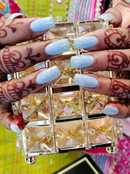 This client was ready for a celebration with her fresh set of light blue glitter nails. These square-shaped extensions look beautiful next to her intricate henna design, showing how I can create the perfect nails for any festive or bridal occasion.
