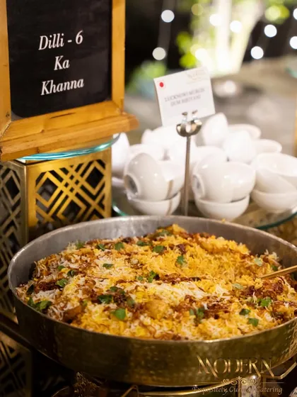 We bring the authentic flavors of Old Delhi to your wedding with our 'Dilli-6 Ka Khanna' station. This features a spread of classic street food and regional specialties, including this aromatic biryani, served in traditional brass cookware for an authentic touch.
