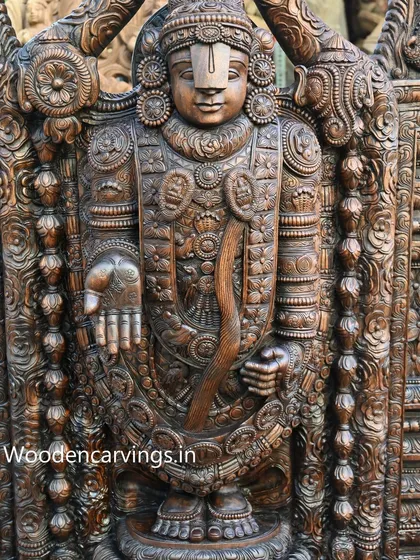 This view of the Lord Venkatajalapathy statue highlights the face and chest, showing the intricate patterns carved into the deity's attire and the traditional Thirunamam on his forehead.