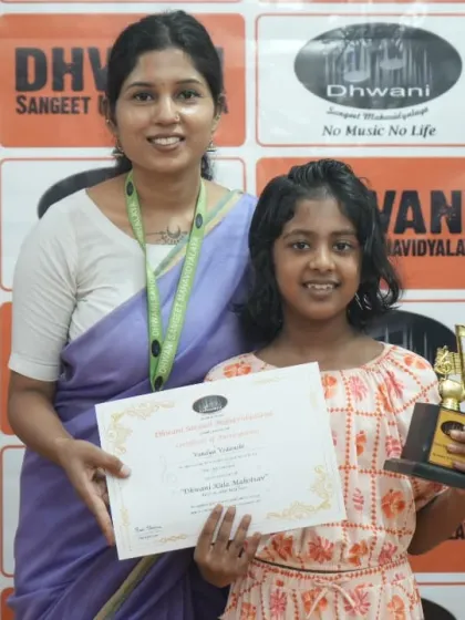 A teacher and student share a smile, celebrating her achievement in the art competition.