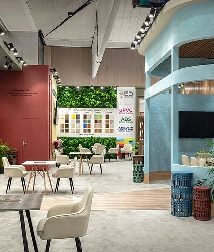 An interior view of the E3 and Skydecor exhibition space, showing how different zones are created using varied color palettes and architectural forms. The design includes a mix of open discussion areas and more intimate meeting nooks.