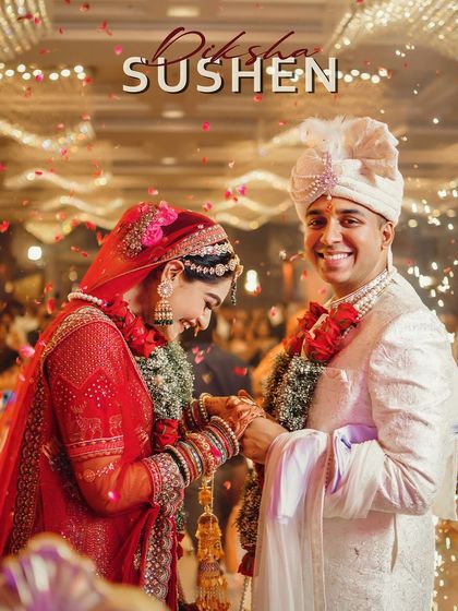 The joy of the Varmala ceremony. This candid shot captures the couple's laughter and happiness as they exchange garlands, surrounded by a shower of flower petals.