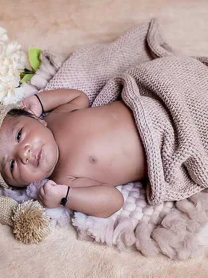 This little one is awake and making a cute expression while lying under a soft blanket. I always work with the baby's mood to get the best possible shots, awake or asleep.