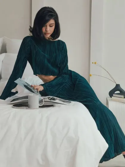 A lifestyle shot of the pleated two-piece set. It's versatile enough to be worn for a relaxed event or dressed up for a more formal occasion.