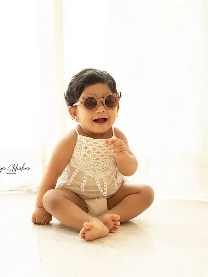 Happiness is here! A simple, bright, and airy studio shot of a happy baby in cool sunglasses. Sometimes the simplest setups allow their personality to shine the brightest.