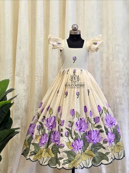 An elegant off-white frock with a beautiful purple lotus print. The simple design and flutter sleeves make it perfect for any special occasion.