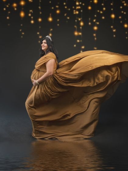 Embracing timeless elegance and golden hues, this stunning maternity portrait is a blend of classic artistry and modern creativity, like a scene from a golden age painting.