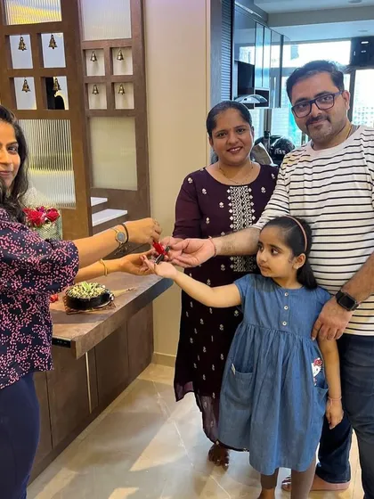 The joy of a new beginning. This photo captures the excitement of a family receiving the keys to their newly designed home, complete with a custom-built console and pooja space.