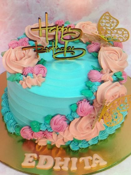 A vibrant floral cake for Edhita. This chocolate mousse cake is decorated with a mix of blue and pink buttercream flowers.