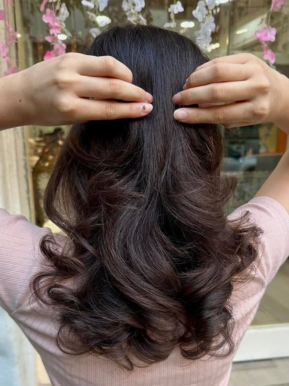 The back view of this simple yet elegant haircut. The soft curls at the ends add volume and a touch of sophistication to her dark hair.
