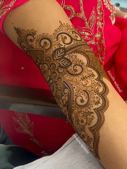 A beautiful Pakistani bridal design for Anam, featuring intricate swirls and floral motifs on the forearm.