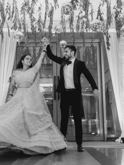 The couple's first dance, captured in a dynamic black and white frame. The motion of the bride's lehenga is beautifully frozen in time.