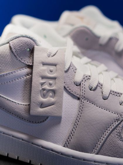 Detail of the 'PRS' leather hangtag and the mix of suede and leather on the upper of the Jordan 1 Low 'Paris'.