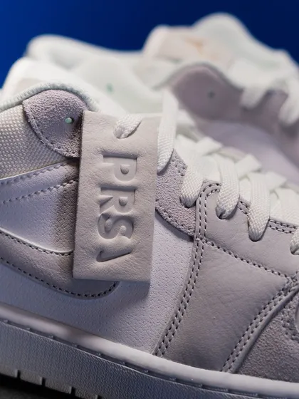 Detail of the 'PRS' leather hangtag and the mix of suede and leather on the upper of the Jordan 1 Low 'Paris'.