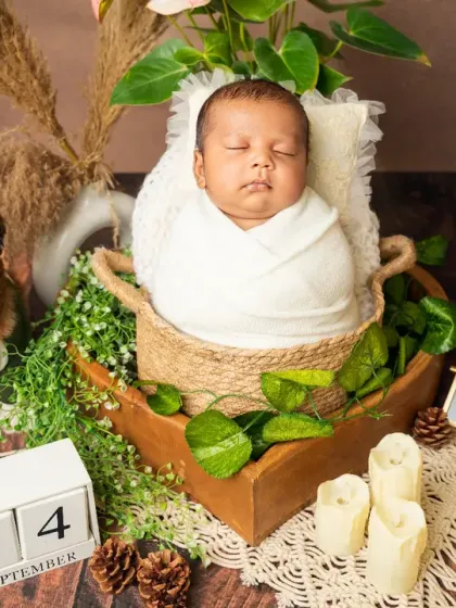 A full view of our pet-friendly newborn session, showing the baby sleeping safely next to his furry big brother, complete with a name and date slate.