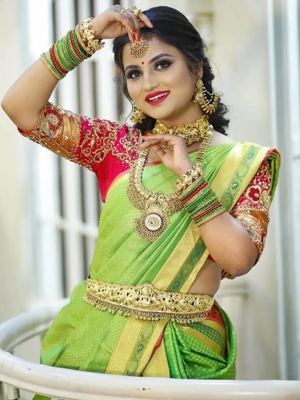 A playful and happy bride-to-be, showing off the intricate bangles and maang tikka from our rental collection.