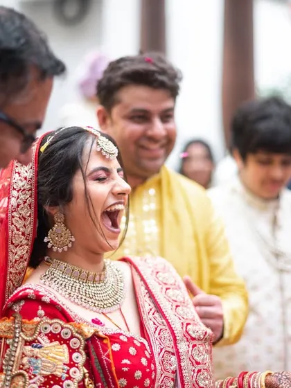 The bride's infectious laughter during a playful wedding ritual.