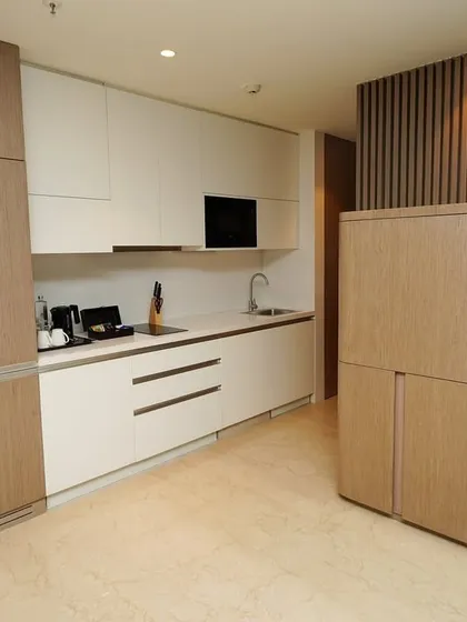 The compact and modern kitchenette area of the suite, featuring integrated appliances and sleek, handleless cabinetry for a minimalist aesthetic.