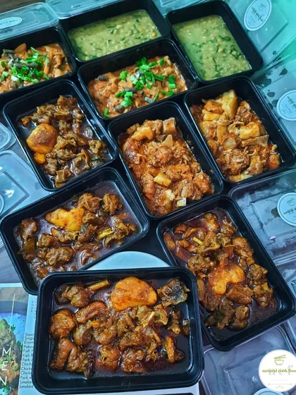 An order being prepared with duck curry, pork with bamboo shoots, 'ooti', and 'eromba'.