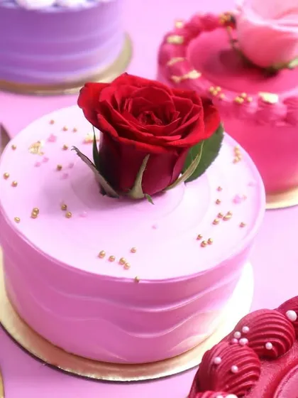 A close-up of our mini cakes for Valentine's week, each topped with a perfect rose and delicate decorations.