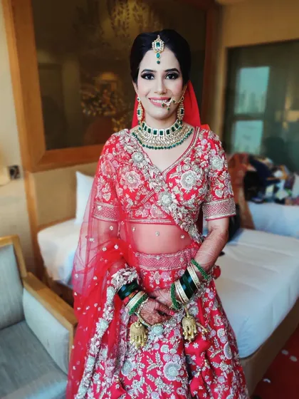 A happy, smiling portrait of the bride in her room before the ceremony. The makeup is fresh and flawless, ready for the big day ahead.