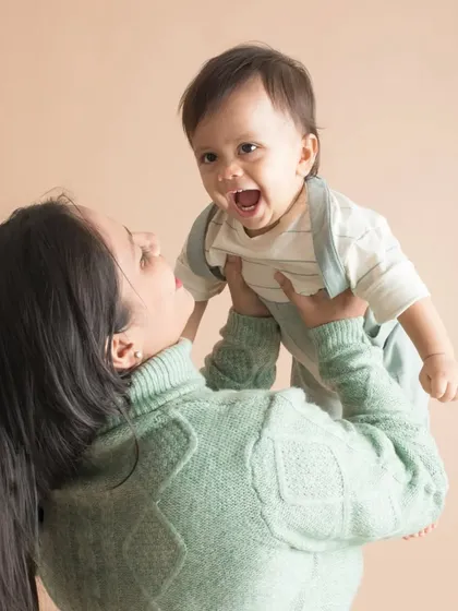 A mother lifts her son into the air, and his face is pure joy. This is the kind of energetic, happy moment I love to freeze in time.