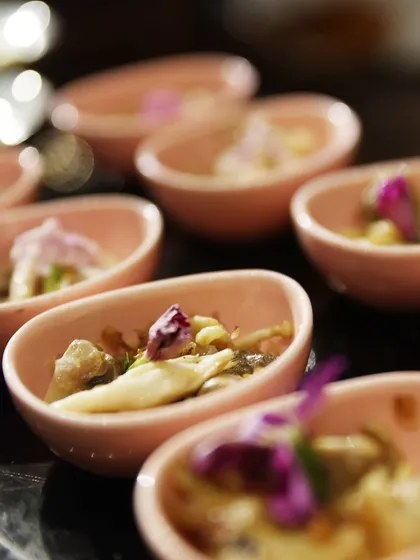 Palate Poetry. Bite-sized appetizers served in delicate pink bowls, each garnished with an edible flower. Every dish is a stanza, every flavour a verse.
