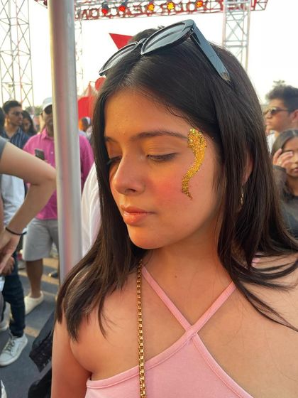 A striking gold glitter snake design on the cheek. This is a bold and glamorous look, perfect for making a statement.