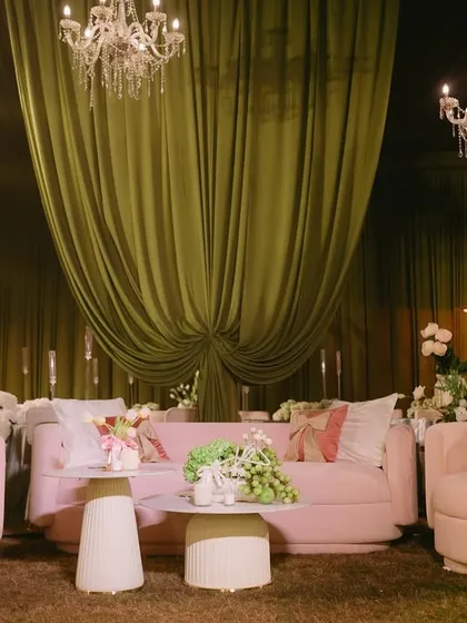 A chic and playful lounge setup for the "Big Bow Affair." I used modern pink sofas and armchairs, complemented by elegant chandeliers and soft green draping, to create a space that felt both stylish and inviting.