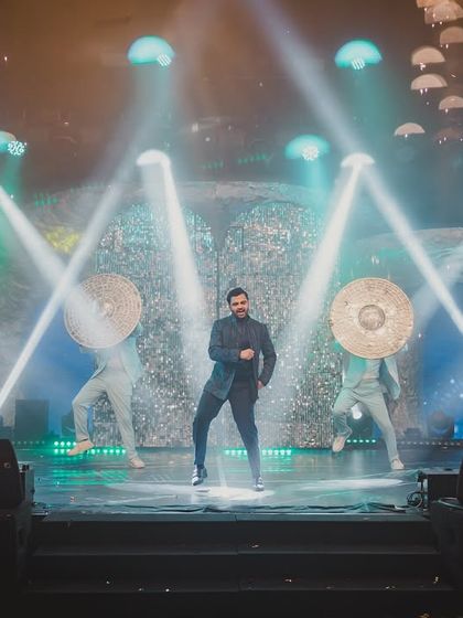 The groom's high-energy solo performance, backed by dancers with unique props, showcasing a dynamic and entertaining Sangeet act.