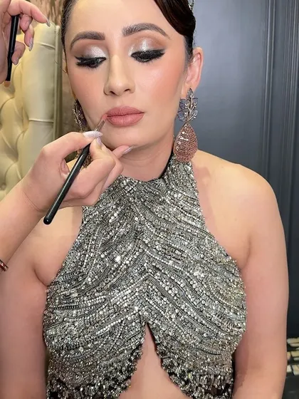 Applying a nude lipstick to complement a silver-toned shimmery eye. This pairing is perfect for a glamorous evening event, creating a look that is both elegant and modern.